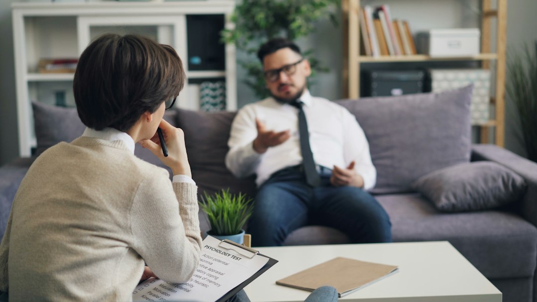 Adult man and woman in a calm mental health consultation setting